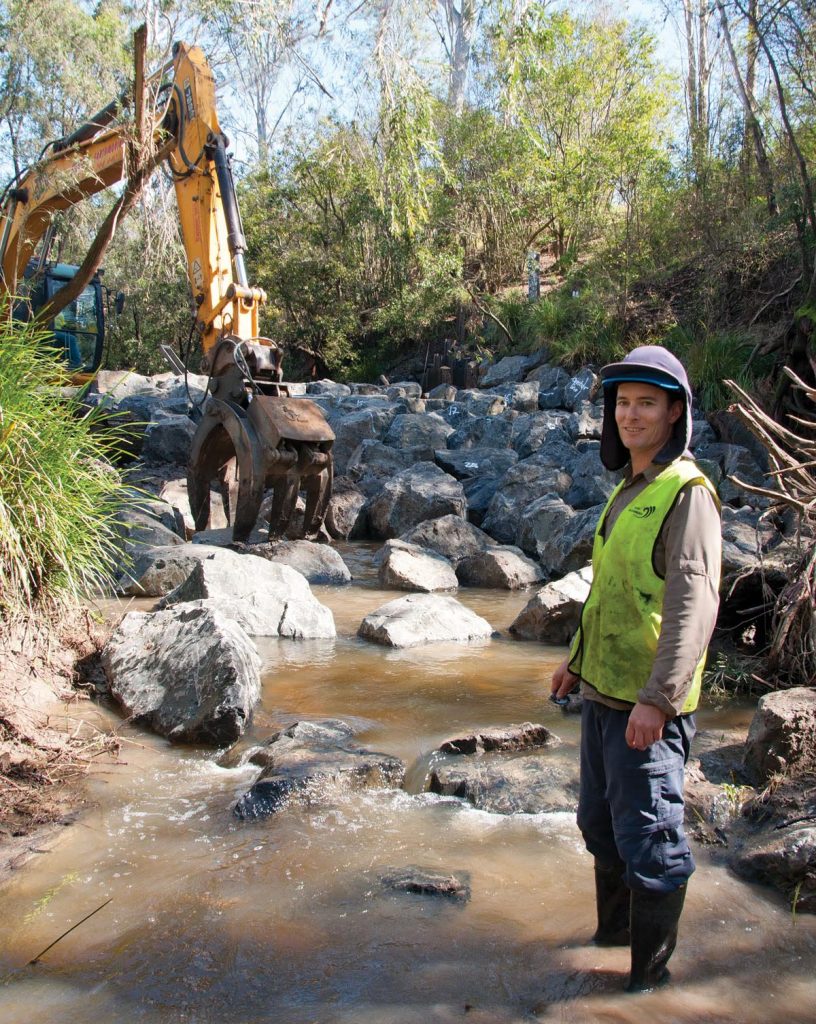Matt Moore from CS Environmental in Mackay on a riverbed with rocks.