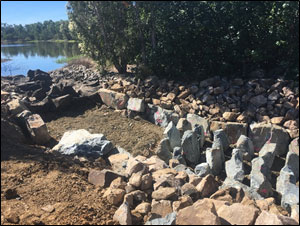 Construction nearing completion, showing ridges towards the top of the fish ladder in place and scour protection visible on the bank.
