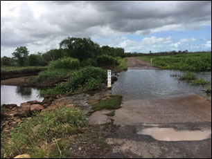 Landing Road causeway fish barrier which bisects the Tedlands wetlands and upper tidal reaches of Rocky Dam Creek in Queensland with damaged fishway adjacent to causeway.