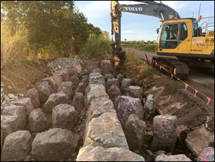 Excavator placing large fishladder ridge and wall rocks during fishladder construction by CS Environmental to construct the pools and ridges of the rock-ramp fishway
