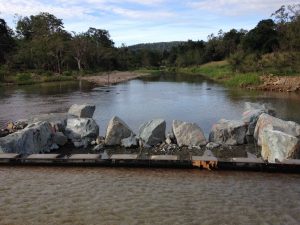 Commencement of fishway construction showing first fishway ridge in place, with first wall rocks also in place.